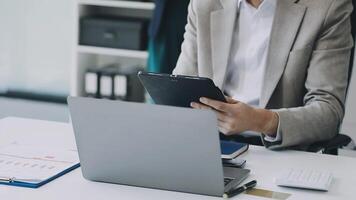 A man in a suit is using a tablet computer video