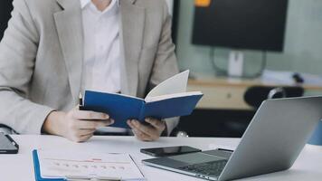 A man in a suit is reading a book while sitting at a desk video
