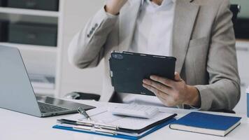 A man in a suit is using a tablet computer video