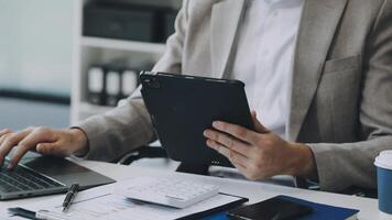 A man in a suit is using a tablet computer video