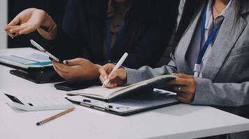 Two business people sitting at a table with a notebook and pen video