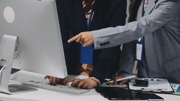 Two business people are pointing at a computer screen video