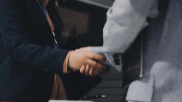 Two people shaking hands in front of a building video