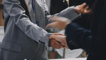 Two business people shaking hands in an office video