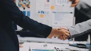 Business people shaking hands in front of a desk video