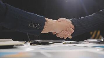 Two business people shaking hands over a desk video