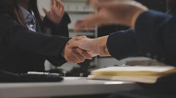 Two business people shaking hands over a desk video