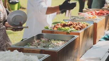 A buffet table with food and people standing around it video