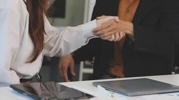 Two people shaking hands over a table video