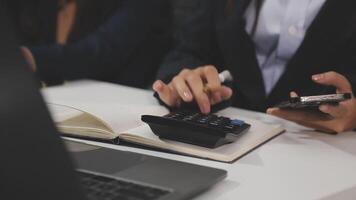 A woman in a business suit using a calculator video