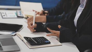 Business people working at a desk with a calculator video