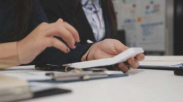 Two people sitting at a table with a piece of paper video