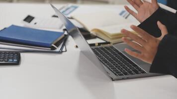 A person in a suit is gesturing while using a laptop video