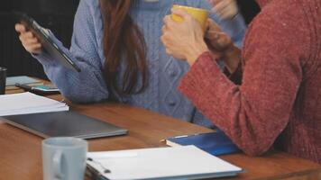 A man and woman sitting at a table with a laptop video