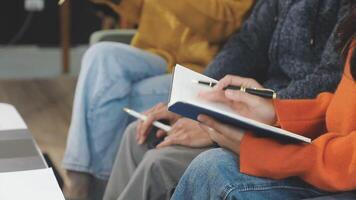 People sitting in a row with notebooks and pens video