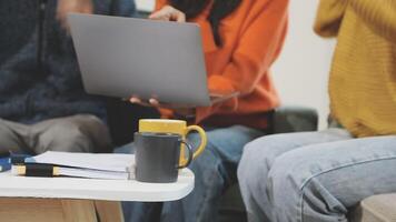 Three people sitting on a couch with a laptop video