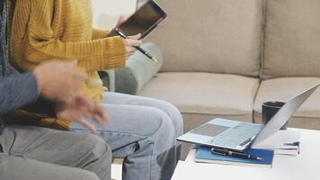 A man and woman sitting on a couch with a laptop video