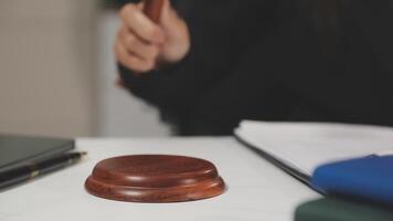 A judge's gavel sitting on a desk next to a pen and notebook video