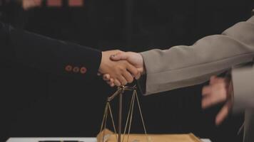 Two business people shaking hands over a scale video