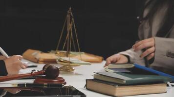 A lawyer and a judge are sitting at a table with books and a gavel video