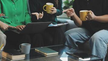 A group of people sitting on a couch with laptops and coffee cups video