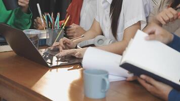 A group of people sitting at a table with laptops video
