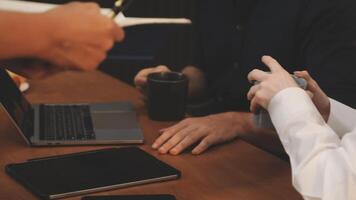 People sitting at a table with laptops and cups video