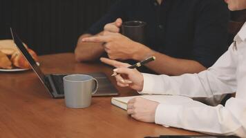 Two people sitting at a table with a laptop and coffee video