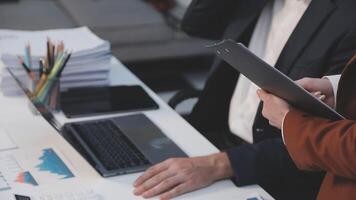 o negócio pessoas trabalhando às uma escrivaninha com uma computador portátil e papéis video