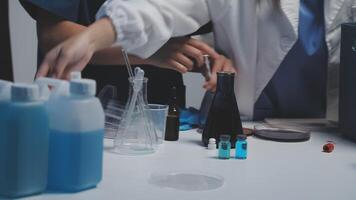 Two people in lab coats are working on a table video