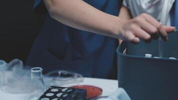 A person in a lab coat is holding a container video