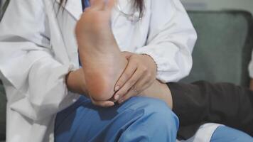 A doctor is holding the foot of a patient video