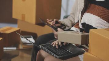 A woman is using a laptop while sitting on a chair with boxes video
