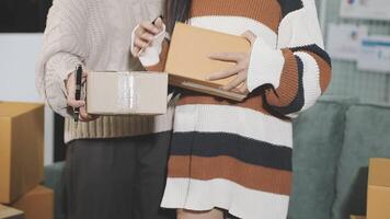 Two people holding boxes in front of a couch video