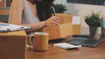 A woman is working on her laptop while sitting at a desk with boxes and a cup of coffee video