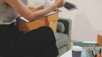 A woman sitting on a couch with a clipboard and papers video