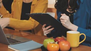Two women are working on a laptop and holding a clipboard video