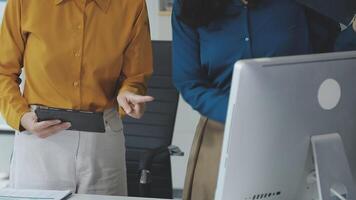 Two women standing in front of a computer video