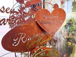 Rustic metal welcome sign in garden with heart and leaves design photo