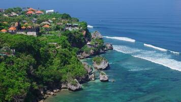 uluwatu área litoral com penhascos, Rocha e oceano com ondas dentro bali. cênico panorama com hotéis e resorts dentro bukit video