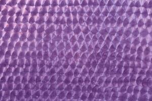 A holographic surface of lilac color with space for copying. Iridescent film texture photo