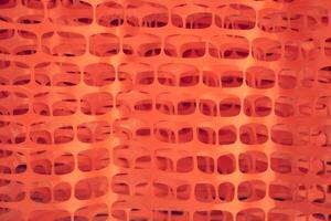 A roll of orange plastic protective barrier mesh. Plastic mesh for fencing, safety warning mesh photo