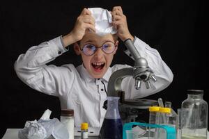 The boy is a scientific researcher with a microscope doing experiments in the laboratory. photo