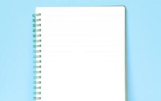 Top view of blank note paper isolated on blue background with copy space. Back to school and education concept, a journaling book photo