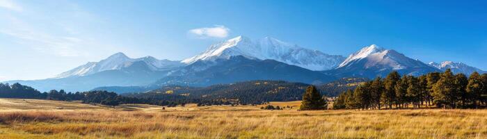 Majestic mountain range with lush fields and clear blue sky photo