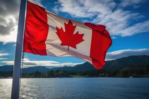 Canadian flag waving over lake with mountains and forest in background photo