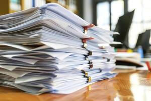 Stack of documents piling up on a desk at the office photo