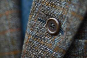 Close up of button on tweed jacket showing detail and texture photo