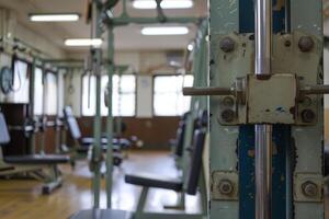 Old weight machine occupying foreground of empty gym photo