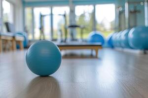 Blue pilates ball sitting on floor in an empty gym photo